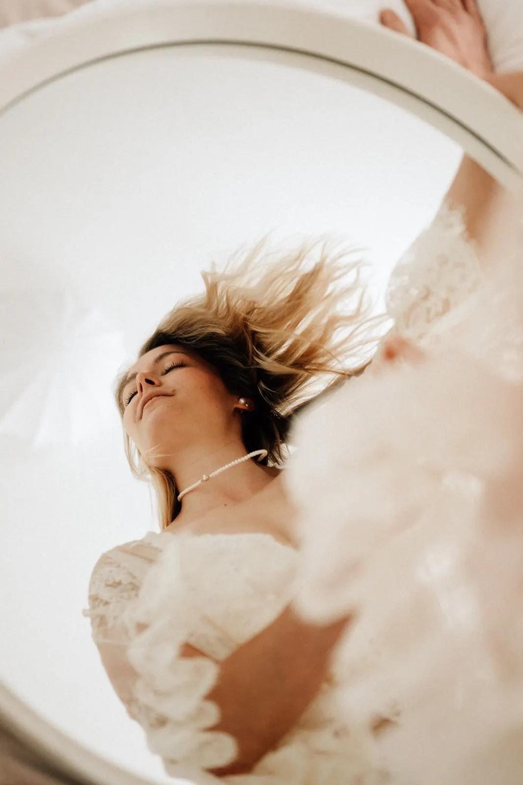 Frau mit fliegenden Haaren im runden Spiegel, helles Boudoir