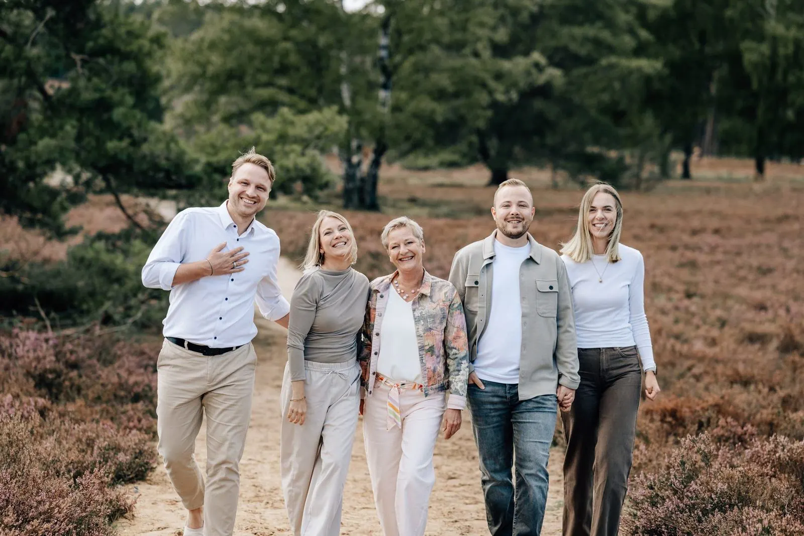 Familie spaziert lachend durch die Fischbeker Heide, Familienfotografie Julia Aßmann