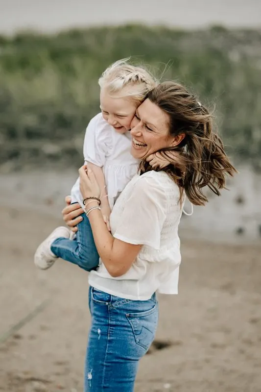 Mutter umarmt Kind am Elbstrand, Familienfotografie im Alten Land