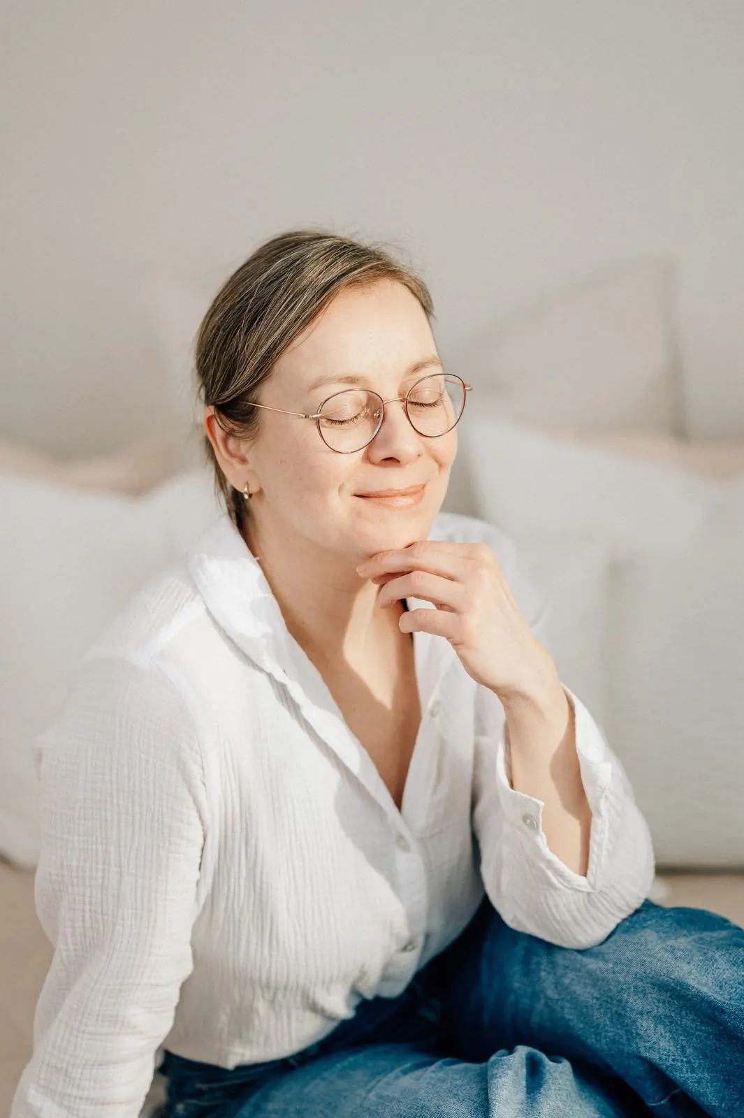 Julia Aßmann mit geschlossenen Augen im warmen Licht ihres Studios